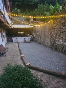 a patio with a bunch of lights and a stone wall at chez Fred in Saint-Rambert-en-Bugey
