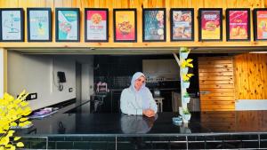a woman standing at a table in a restaurant at Hostalio Pyramid View in Cairo