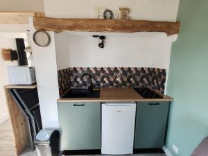 a small kitchen with a sink and a counter at Le Gîte d'Amoé in Mélamare