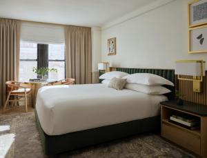 a hotel room with a large bed and a desk at 70 Park Avenue Hotel in New York