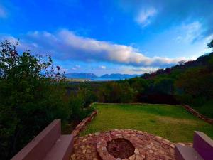 un banco en un campo con vistas a las montañas en Anahata Nature Resort, en Hartbeespoort 5 fotos más