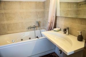a bathroom with a sink and a bath tub at Viva B&B in Anavyssos