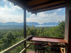 2 sillas en un porche con vistas al océano en Anahata Nature Resort, en Hartbeespoort