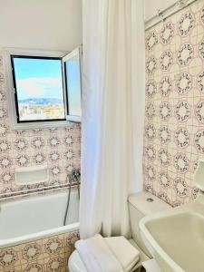 a bathroom with a white toilet and a window at Athens sky & Acropolis view rooftop apartment! in Athens +18 photos