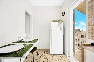 a white refrigerator in a kitchen with a table and chairs at Athens sky & Acropolis view rooftop apartment! in Athens