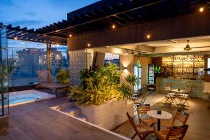 a rooftop patio with tables and chairs on a building at Mosaic Studios Buenavista in Barranquilla