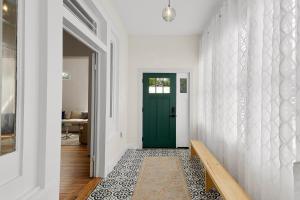 a hallway with a green door and a bench at Ellie Marie House LITE in Seguin