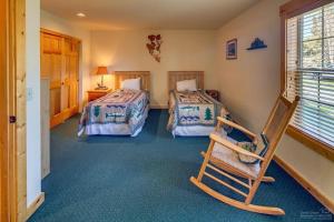 a bedroom with two beds and a rocking chair at Forest Ridge home in Redmond