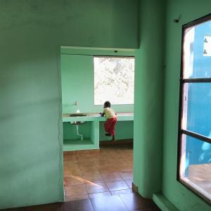 una persona seduta a una scrivania in una stanza verde di Tranquality ad Auroville