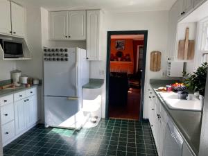 a kitchen with a white refrigerator and a green tile floor at North Portland 2BR Garden Home - Walk to shops, food and transit in Portland