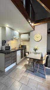 a kitchen with a table and a clock on the wall at Alsace in Beauvais +31 photos