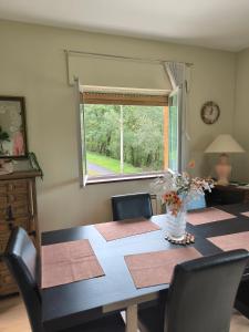 a dining room table with chairs and a window at Casa las granxias in El Escobal