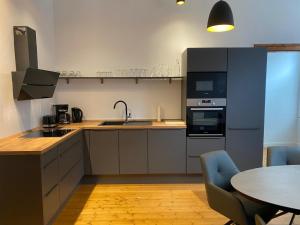 a kitchen with a sink and a table with chairs at Stadtwohnung im Altbaustil in Paderborn
