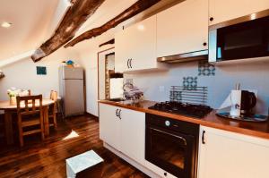 a kitchen with white cabinets and a black stove top oven at Les Coumayres in Riols