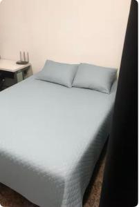 a white bed with two pillows on top of it at Faça tudo a pé in Limeira