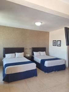 a hotel room with two beds and a tv at Hotel Ruiz Milán in Veracruz