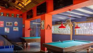 una sala da biliardo con due tavoli da biliardo e travi rosse di Zuana Beach Resort a Playa Dormida