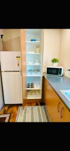 a kitchen with an open refrigerator and a sink at Parnell pavilion-Elegant escape at Central Auckland in Auckland
