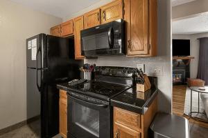 スティームボート・スプリングズにあるPowder Peak Retreatのキッチン(黒いコンロ、冷蔵庫付)