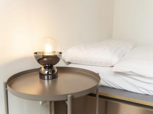 a table with a candle on it next to a bed at WYBA Living, stilvoll&zentral in St Gallen -6min zur Olma Messe in St. Gallen