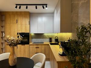 a kitchen with a table and a vase of flowers at Family & Business Apartments PREMIUM No1 - 1 Bedroom with Private Jacuzzi, Balcony, Parking in Warsaw