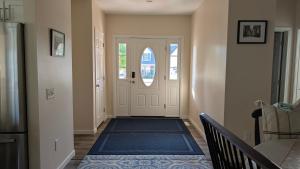 a hallway with a white door with a blue rug at Spacious Entire home close to HoliMont and Village in Ellicottville