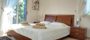 Un dormitorio con una cama con dos almohadas encima. en Latchi coast villa-resort, en Lachi
