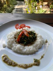 a plate of food with rice and tomatoes on it at Ningmas Escape by Sidhi Hospitality Experiences in Ubud