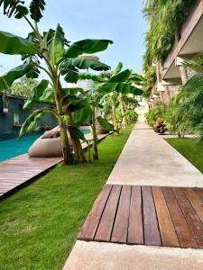 a garden with a wooden path next to a house at TULUM XAMIRA PRIVATE SPA Balcony in Tulum