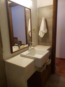 a bathroom with a white sink and a mirror at Casa patio y parrillero in Montevideo +24 photos
