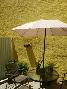 a table and a chair and an umbrella on a patio at Casa patio y parrillero in Montevideo