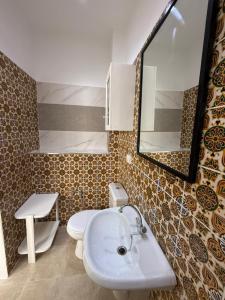 Un baño con lavabo, inodoro y espejo. en L'expérience Roof Top de La Marsa, 