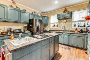 a kitchen with blue cabinets and a sink at 9 Mi to Downtown Atlanta Home with Deck and Yard! in Tolliver Heights