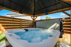 a hot tub under an umbrella in a backyard at Hearth Haven - Hot Tub BBQ Large Groups in Colorado Springs