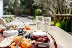 a table with a plate of food and glasses of wine at Westholm Lodge in Harihari