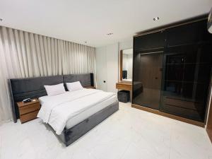 a bedroom with a large bed and a glass wall at كمبوند الكناريا عماره 81 in Sheikh Zayed