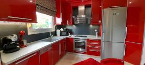 a kitchen with red cabinets and a silver refrigerator at Indepented Residence Serres in Levkón