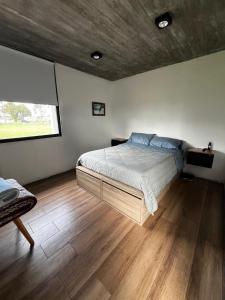 Un dormitorio con una cama grande y una ventana. en Casa las lomas, en Miramar