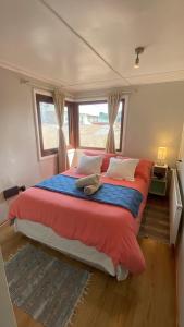a bedroom with a large bed with a red blanket at Patagon Backpackers in Coihaique