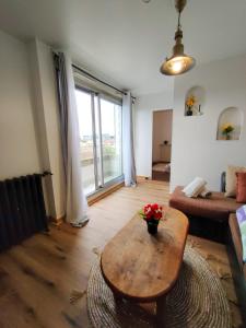 a living room with a wooden table and a couch at Le Balcon Victor Hugo - Clichy Paris in Clichy