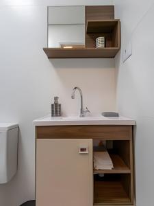 a kitchen with a sink and a refrigerator at Flats Cotia in Cotia