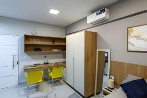 eine kleine Küche mit einem Tisch und gelben Stühlen in der Unterkunft Flats Cotia in Cotia