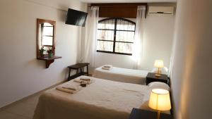 two beds in a room with two lamps and a window at Hotel Maspalomas in Villa Carlos Paz +96 photos