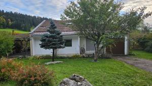 una casa blanca con un árbol en el patio en Appartement le Refuge du Cerisier, en La Chaux-de-Fonds
