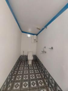 La salle de bains est pourvue de toilettes et de carrelage. dans l'établissement Nikhils Luxury Beach Cottages, à Magdāl