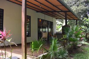 a porch of a house with a pergola at Casa de Campo Riverside in Puerto Quito
