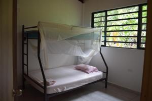 a bunk bed in a room with a window at Casa de Campo Riverside in Puerto Quito
