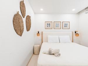 a white bedroom with a white bed and some pictures on the wall at The Hills Residence at Simpson Bay in Simpson Bay +28 photos
