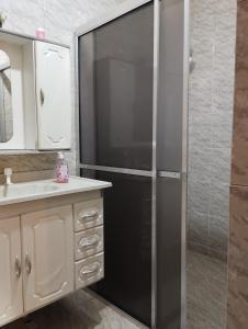 una nevera negra en el baño con lavabo en Casa Aconchegante, en Caparaó Velho