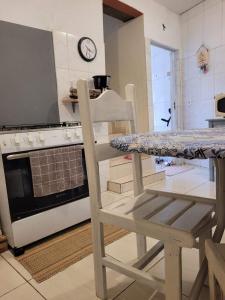 Una cocina con una mesa y una silla frente a un horno. en Casa Aconchegante, en Caparaó Velho